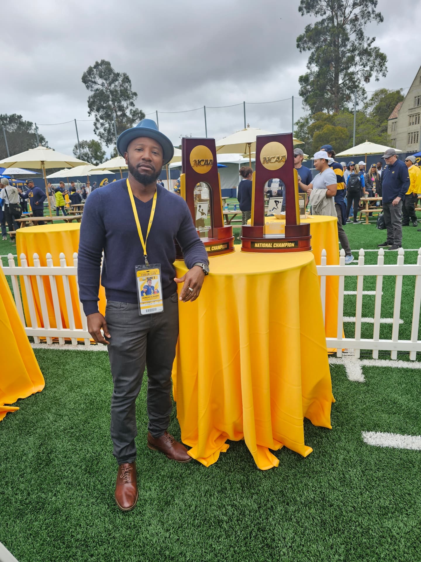 Marc at a Cal athletics championship event beside NCAA national champion trophies